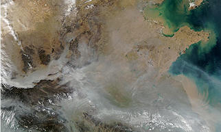 Sediments discharge into the Bo Hai Bay and western Yellow Sea colouring the surface waters caramel in this satellite view of China. Light brown hues show bare land, darker browns areas of vegetation. Photograph: Modis/Nasa